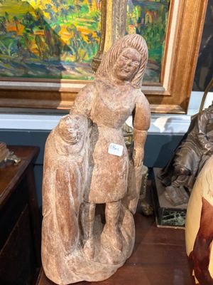 une statue de femme tenant un enfant sur une table