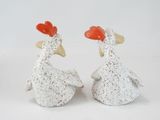 two ceramic chickens that are standing next to each other