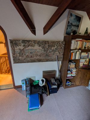 une pièce avec un lit, une bibliothèque et une chaise