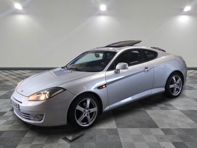 une photo d'une voiture de sport argentée dans un showroom