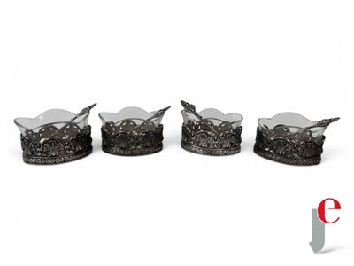 four pieces of silverware with spoons and spoon rest on a white surface
