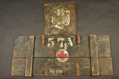 a wooden sign with a red cross and a coat of arms