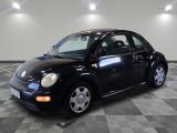 une photo d'une Coccinelle Volkswagen noire garée sur un sol à damier