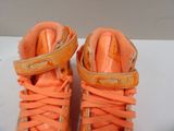 a pair of orange shoes with orange laces on them