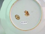 a white and green plate with a brown mouse on it