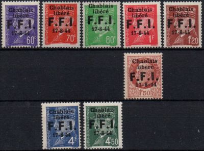 several different colored postages are on a black surface
