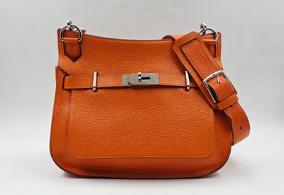 un gros plan d'un sac à main orange sur fond blanc