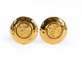 a pair of gold toned earrings with a circular design