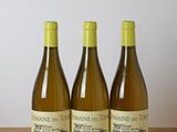 three bottles of wine sitting on top of a wooden table