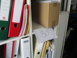 une étagère sur laquelle sont posés plusieurs classeurs
