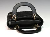 a small black purse that is on a white surface