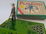 an image of a toy man with a golf racket and a box of golf balls