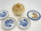 quatre petites assiettes bleues et blanches et un petit bol posés sur une table