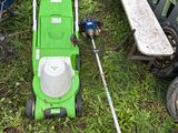 une tondeuse à gazon verte posée sur l'herbe, à côté d'autres tondeuses à gazon