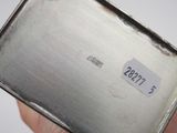 someone is holding a metal box with a sticker on it