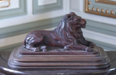 une statue de lion assis sur une table
