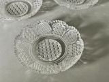 three glass dishes sitting on a table with a white table cloth