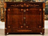 an antique chest of drawers in a room with a tapestry on the wall