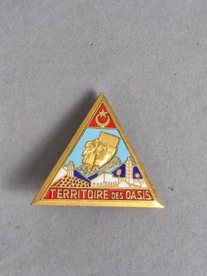 un gros plan d'une broche en forme de triangle sur laquelle figure l'image d'un homme à cheval