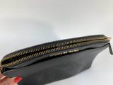 a person holding a black purse with gold zippers on it