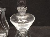 two glass perfume bottles sitting next to each other on a table