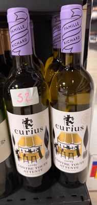 trois bouteilles de vin sont posées sur une étagère dans un magasin