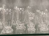 une étagère en verre sur laquelle sont posés de nombreux verres