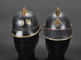 two helmets with gold spikes on them sitting next to each other