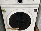 a white washing machine sitting on a pallet in a room
