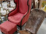 un fauteuil rouge et un pouf dans une pièce remplie de meubles anciens