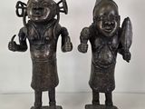 pair of bronze figurines of a man and a woman holding a knife and fork