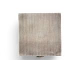 a silver object on a white surface with a white background