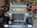 a military jeep with a star on the front parked in a garage