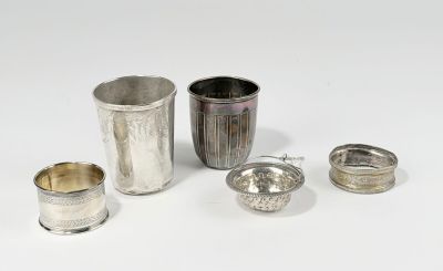 quatre tasses en argent et une cuillère en argent posées sur un plateau blanc