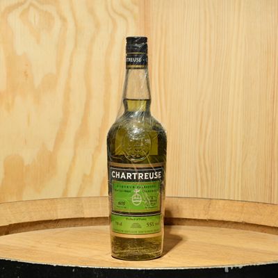 a bottle of chartreuse sitting on top of a barrel