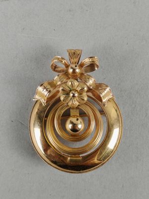 an image of a gold plated brooch with a flower decoration
