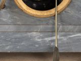 a clock that is sitting on the floor next to a bowl