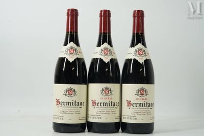 three bottles of red wine sitting on top of a white table