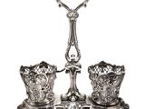 une paire de bougeoirs en argent posés sur un socle, sur fond blanc