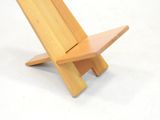 a wooden chair that is sitting on a white surface