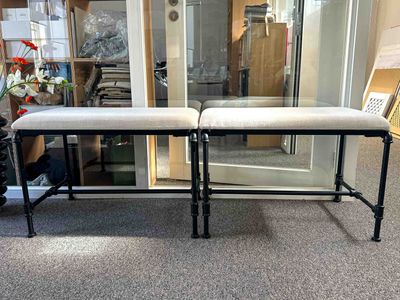 two benches that are sitting in front of a glass door