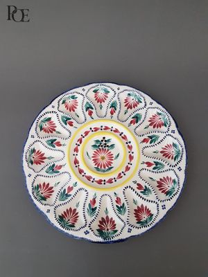 une assiette blanche ornée de motifs rouges et verts