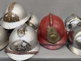 five helmets sitting on a table with one red one silver and one gold
