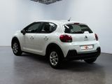 the rear of a white car is parked in a large room