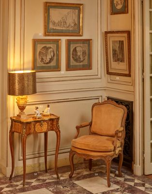 une chaise et une table dans une pièce où il y a des tableaux accrochés au mur