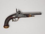 un vieux pistolet avec une poignée en bois sur une surface blanche