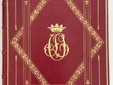 a red book with gold trim and a crown on the cover