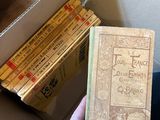 une personne tenant un livre devant une boîte remplie de livres