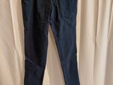 a pair of dark blue pants hanging on a hanger