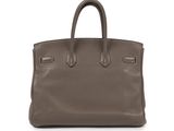 a brown leather handbag on a white background